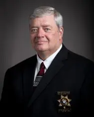 A man in a suit and tie wearing a badge.