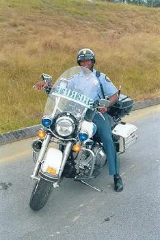 A police officer sitting on the back of his motorcycle.